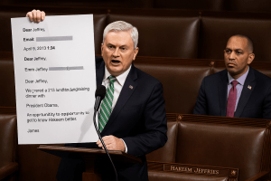 James Comer holds a blown up email addressed to Jeffrey Epstein on the House floor while Hakeem Jeffries watches from behind.