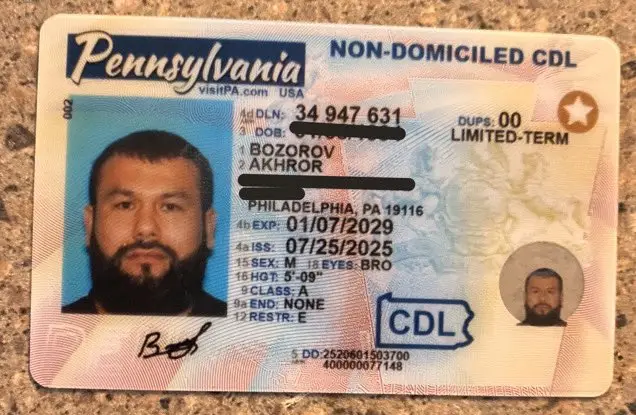 A photograph of a Pennsylvania non domiciled CDL belonging to Akhror Bozorov, the Uzbek national arrested by ICE in Kansas. The license shows standard CDL identifiers including photo, name, expiration date, address, and classification markings. Used for reporting on his work authorization and commercial driving status in the United States.