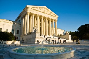 Exterior view of the U S Supreme Court building with fountain and visitors in front