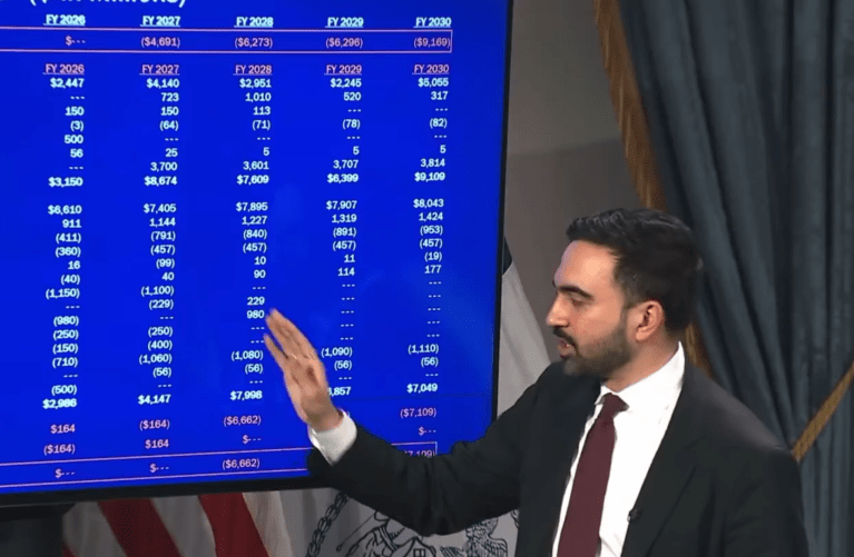 City official presenting a budget slide with projected fiscal numbers during a briefing on a proposed property tax increase.