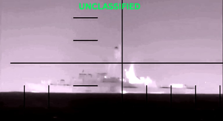 Thermal periscope view of a warship on fire at sea with UNCLASSIFIED overlay